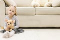 Cute happy little casual girl embracing teddy bear sharing secrets with her favorite toy friend. Royalty Free Stock Photo