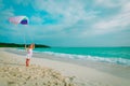Cute happy little girl flying a kite at sky on beach Royalty Free Stock Photo