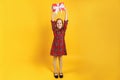 Cute happy little girl holding a box with a gift over her head. A child in a full-length with pigtails in a red dress Royalty Free Stock Photo