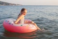 Cute happy little girl learning swim at the ocean with pink inflatable ring Royalty Free Stock Photo