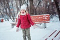 Cute happy little girl playing with snow and laughing in winter park Royalty Free Stock Photo