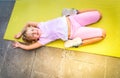 Cute happy little girl in sportswear smiling at camera while while exercising on seaside Royalty Free Stock Photo