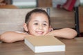 Cute happy little girl student leaning on table with book in classroom elementary school . kid or child clever sitting at desk Royalty Free Stock Photo