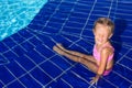 Cute happy little girl in the swimming pool looks Royalty Free Stock Photo