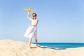 Cute happy little girl wearing sun eyeglasses and a white dress evolving in the wind playing with the yellow Royalty Free Stock Photo