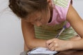 Cute happy little girl writing something in her notebook Royalty Free Stock Photo