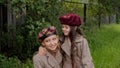 Cute happy little girls in berets hugging outdoors