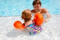 Cute happy little toddler girl and father in the pool and having fun on family vacations in a hotel resort. Healthy Royalty Free Stock Photo