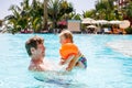 Cute happy little toddler girl and father in the pool and having fun on family vacations in a hotel resort. Healthy Royalty Free Stock Photo