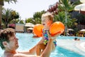 Cute happy little toddler girl and father in the pool and having fun on family vacations in a hotel resort. Healthy Royalty Free Stock Photo