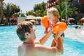 Cute happy little toddler girl and father in the pool and having fun on family vacations in a hotel resort. Healthy Royalty Free Stock Photo