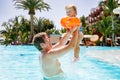 Cute happy little toddler girl and father in the pool and having fun on family vacations in a hotel resort. Healthy Royalty Free Stock Photo