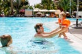 Cute happy little toddler girl, school kid boy and father in the pool and having fun on family vacations in a hotel Royalty Free Stock Photo
