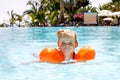 Cute happy little toddler girl swimming in the pool and having fun on family vacations in a hotel resort. Healthy child Royalty Free Stock Photo