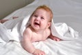 Cute happy 4 month baby boy or girl lying on a white towel Royalty Free Stock Photo