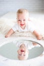 Cute happy 7 month baby girl in diaper lying and playing. Royalty Free Stock Photo