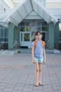 Cute schoolgirl with backpack leaving school