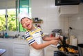 Cute happy smiling Asian boy child wearing chef hat and apron having fun preparing, cooking healthy Homemade Japanese Curry Rice Royalty Free Stock Photo