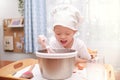 Cute Asian 4 years old boy child having fun preparing cake or pancakes enjoy process mixes dough using whisk at home, Fun indoor