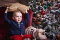 Child boy holding a star shape pillow near christmas decoration Royalty Free Stock Photo