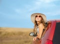 Cute happy smiling little girl child goes to summer travel trip in the red car Royalty Free Stock Photo