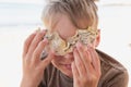 Cute happy smiling white kid holding yellow seashells near eyes smiling Royalty Free Stock Photo