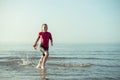 Cute happy teen child girl running in water in Baltic sea Royalty Free Stock Photo