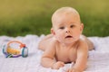 Cute happy toddler lying on a blanket on the grass outdoors in summer Royalty Free Stock Photo