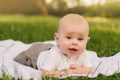 Cute happy toddler lying on a blanket on the grass outdoors in summer Royalty Free Stock Photo