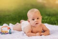 Cute happy toddler lying on a blanket on the grass outdoors in summer Royalty Free Stock Photo