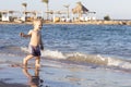 Cute happy toddler on the sea shore. Funny baby boy on vacation Royalty Free Stock Photo