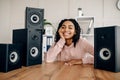 Cute happy woman between many audio speakers