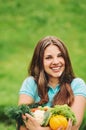 Cute happy woman with organic healthy fruits and vegetables on t