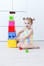 Cute happy 2 years toddler girl playing with educational toy at