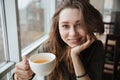 Cute happy young beautiful lady sitting in cafe drinking tea Royalty Free Stock Photo