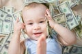 Cute hapy baby boy playing with a lot of money, american hundred dollars cash