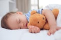 Cute healthy little Asian 1 year old toddler baby boy child sleeping, taking a nap under blanket in bed Royalty Free Stock Photo