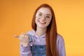 Cute helpful friendly-looking joyful european redhead woman show thumb left smiling delighted laughing pointing where