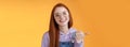 Cute helpful friendly-looking joyful european redhead woman show thumb left smiling delighted laughing pointing where