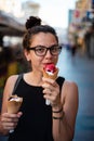 Girl eating two ice creams on the street Royalty Free Stock Photo