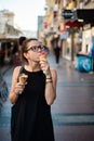 Girl eating two ice creams on the street Royalty Free Stock Photo