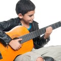 Cute hispanic boy playing an acoustic guitar Royalty Free Stock Photo