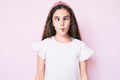 Cute hispanic child girl wearing casual clothes and diadem making fish face with lips, crazy and comical gesture Royalty Free Stock Photo