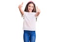 Cute hispanic child girl wearing casual white tshirt approving doing positive gesture with hand, thumbs up smiling and happy for Royalty Free Stock Photo