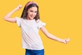 Cute hispanic child girl wearing casual white tshirt dancing happy and cheerful, smiling moving casual and confident listening to Royalty Free Stock Photo