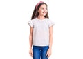 Cute hispanic child girl wearing casual white tshirt looking away to side with smile on face, natural expression Royalty Free Stock Photo