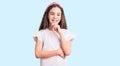 Cute hispanic child girl wearing casual white tshirt looking confident at the camera smiling with crossed arms and hand raised on Royalty Free Stock Photo