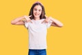 Cute hispanic child girl wearing casual white tshirt looking confident with smile on face, pointing oneself with fingers proud and Royalty Free Stock Photo