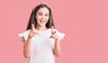 Cute hispanic child girl wearing casual white tshirt pointing fingers to camera with happy and funny face Royalty Free Stock Photo