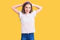 Cute hispanic child girl wearing casual white tshirt relaxing and stretching, arms and hands behind head and neck smiling happy Royalty Free Stock Photo